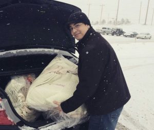 Victor Rio, founder of Expose Design LLC loading a car with marketing materials