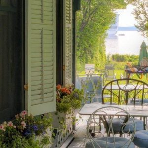 Shore Path Cottage porch view with tables and water in the distance