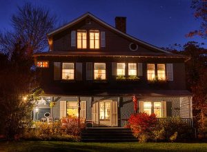 Shore Path Cottage Building at night with glowing widows lit from within