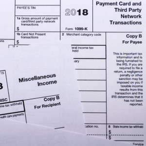 2018 1099K tax form and other miscellaneous tax forms on top of each other.