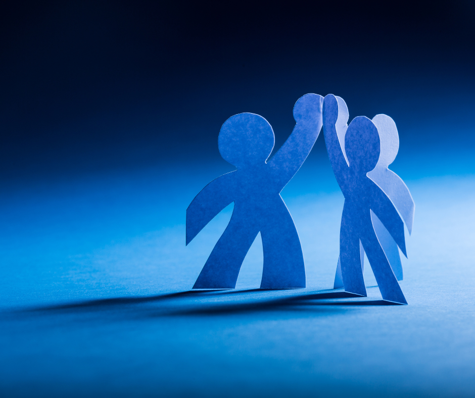Blue cut out paper people giving each other a high five on a blue to black gradient background