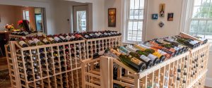 Photo of the inside of Wine House on Main shop showing wine display, widows and small wall art.