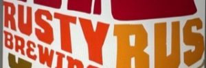 Rusty Bus Brewing Logo, red, orange and yellow type is in the shape of a bus