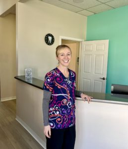 a smiling white woman at a front desk