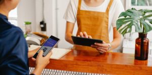 Interaction at a counter with two digital devices, looks like a transaction is occurring.