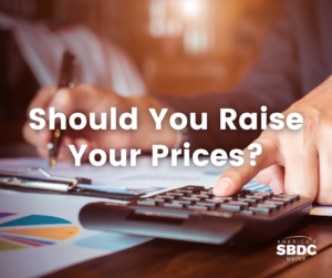 Should You Raise Your Prices? text over an image hands working at a desk writing and using a calculator