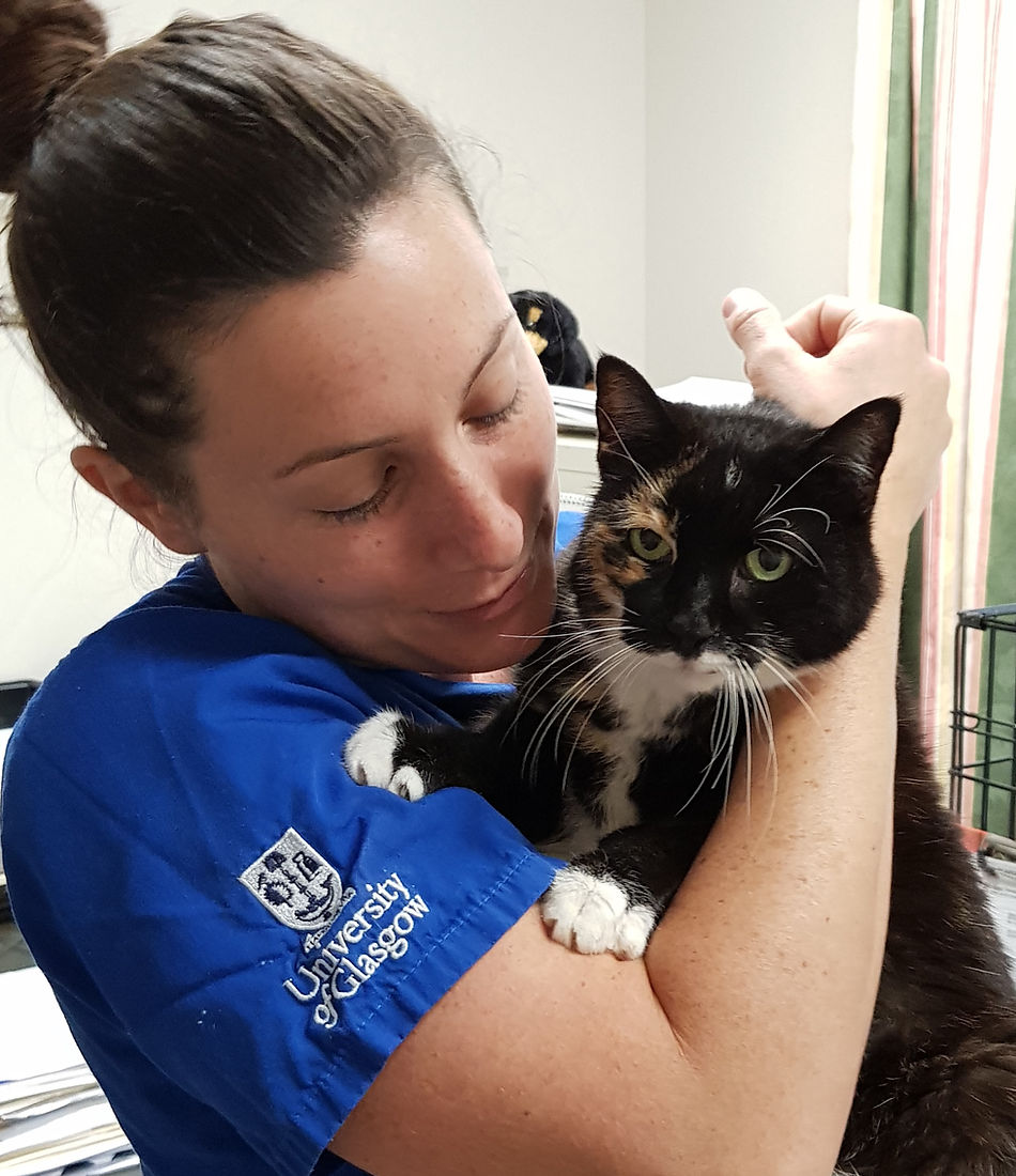 Dr. Sarah Spindell of Fantastic Beasts Veterinary Care holding a black and white cat.