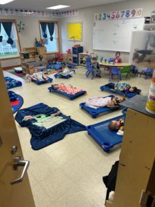 Classroom with young children on blue sleeping mats