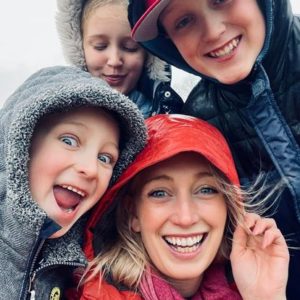 Chelsie Crane and her family smiling, selfie, close up in jackets,