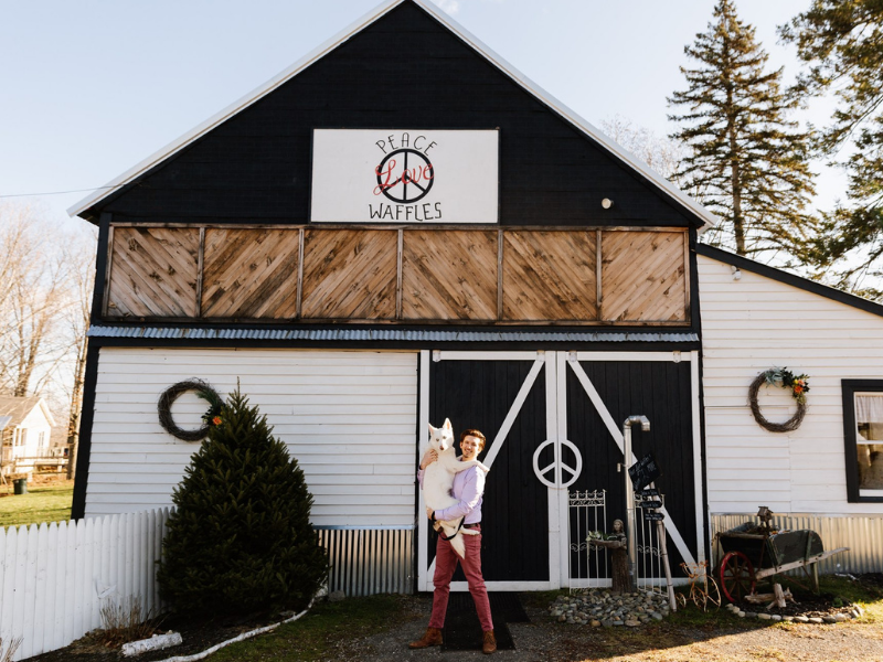 The Waffle Barn at Peace Love Waffles with Business Owner Michael Begley out front with cute, white dog