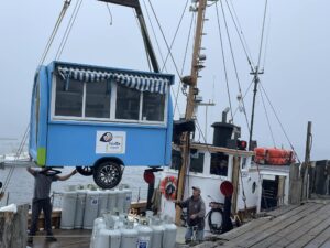 Palette Creperie food trailer being lifted off a boat on Monhegan Island