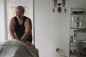 Stefani Sellers, owner of Ease Massage & Manual Therapy, giving a massage, smiling