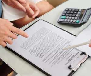 Decorative imagery of a clipboard with a lease. Someone is pointing to the lease with a pen and someone is pointing at a section of the release with their finger