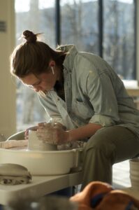 Focused person while working at a pottery wheel at Handful Studios in Portland