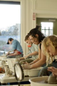 Focused group working at pottery wheels at Handful Studios in Portland